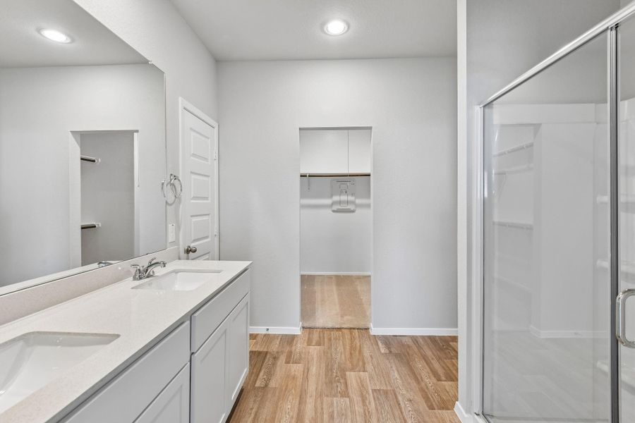 The primary bathroom features a spacious and well-designed layout, centered around both comfort and functionality.