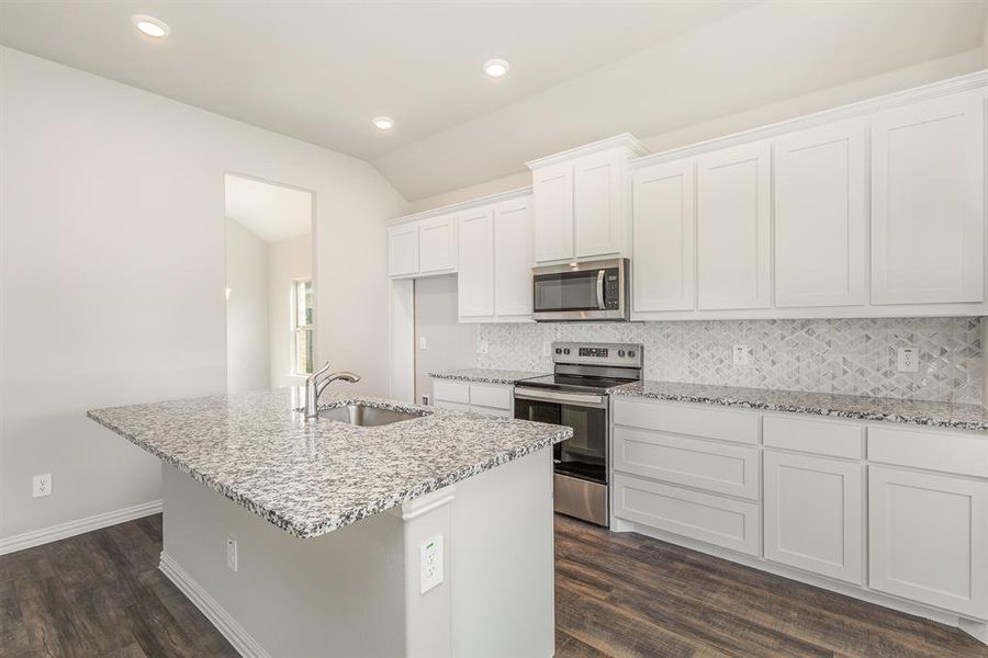 Kitchen featuring white cabinetry, an island with sink, dark wood-type flooring, and appliances with stainless steel finishes