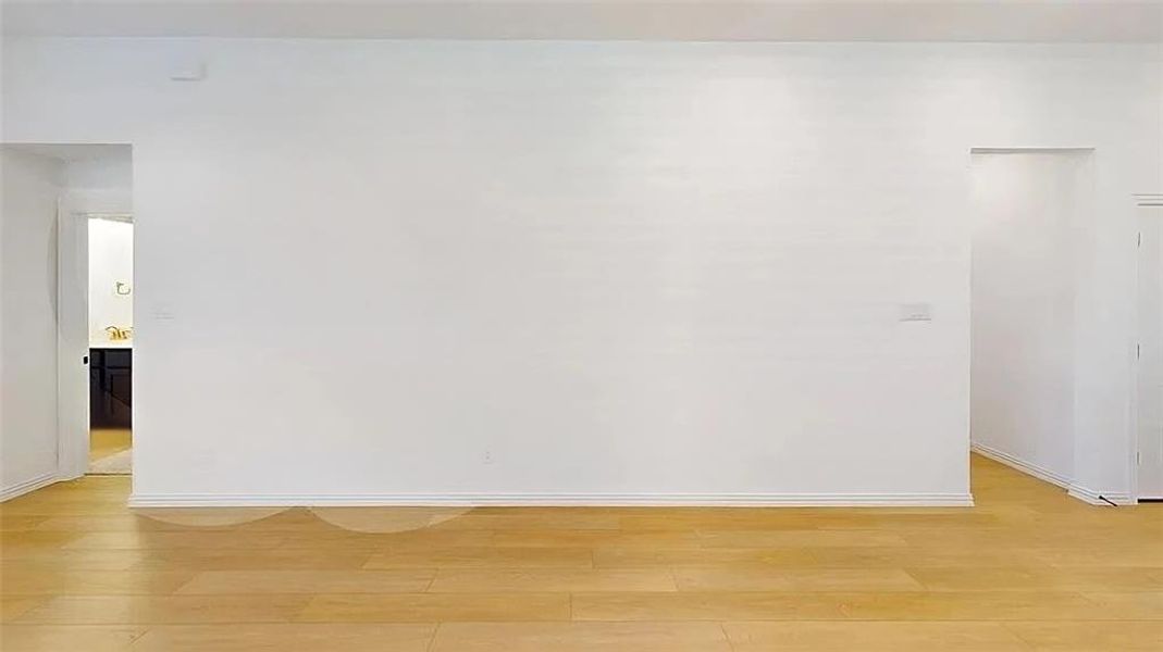 Spare room featuring light wood-style flooring and baseboards