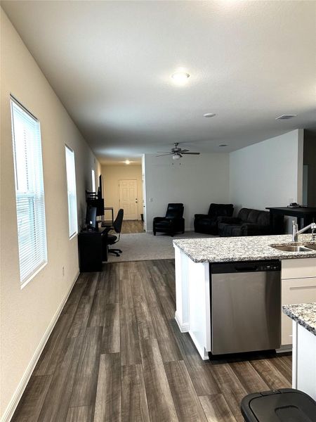 Kitchen with dark wood finished floors, visible vents, white cabinets, a sink, and dishwasher