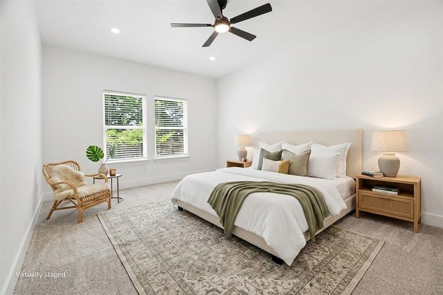 The property features a spacious room with light-colored carpeting, two windows providing natural light, and a ceiling fan with integrated lighting