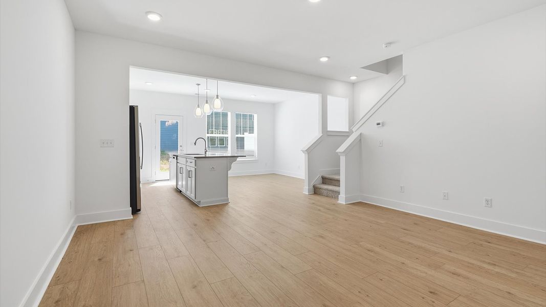 Spacious family room with rich hardwood flooring and elegant trim work in a reputable DRB Homes build Spacious family room with rich hardwood flooring and elegant trim work in a reputable DRB Homes build