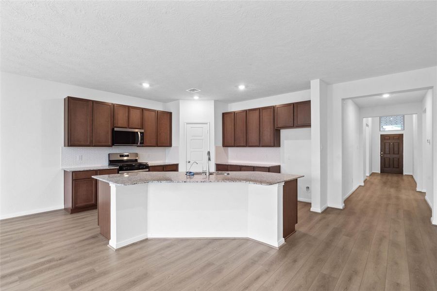 Thoughtfully designed with an open layout, the Great Room offers clear sightlines to the entryway, ensuring you remain effortlessly connected to guests and family the moment they step through the front door.