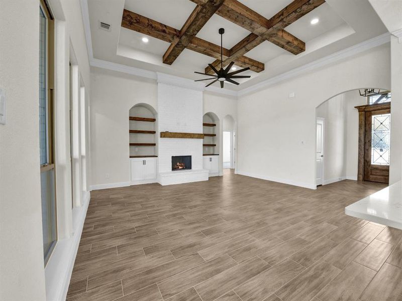 Unfurnished living room with a ceiling fan, arched walkways, and wood finish floors Unfurnished living room with a ceiling fan, arched walkways, and wood finish floors