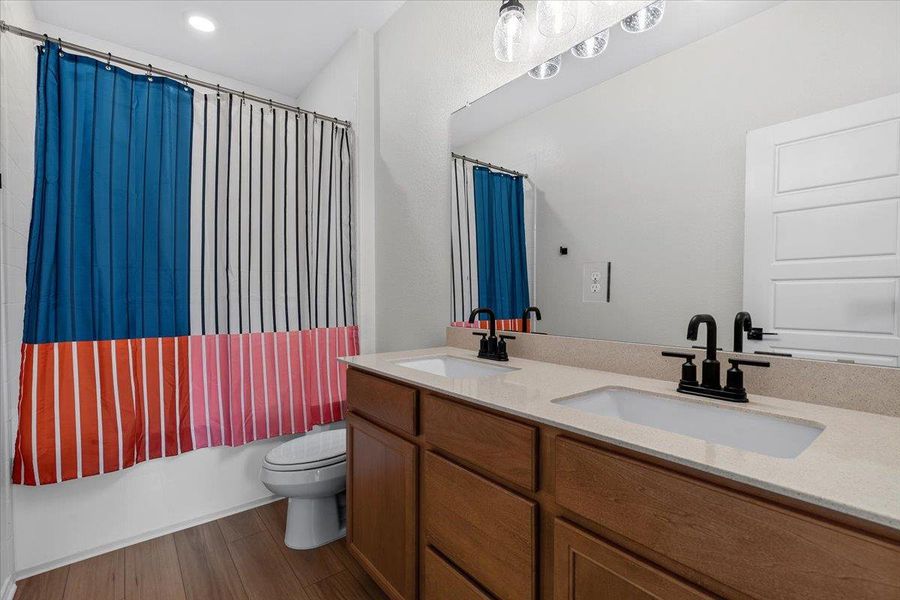 Double vanity with modern black fixtures enhances this practical and stylish bathroom.