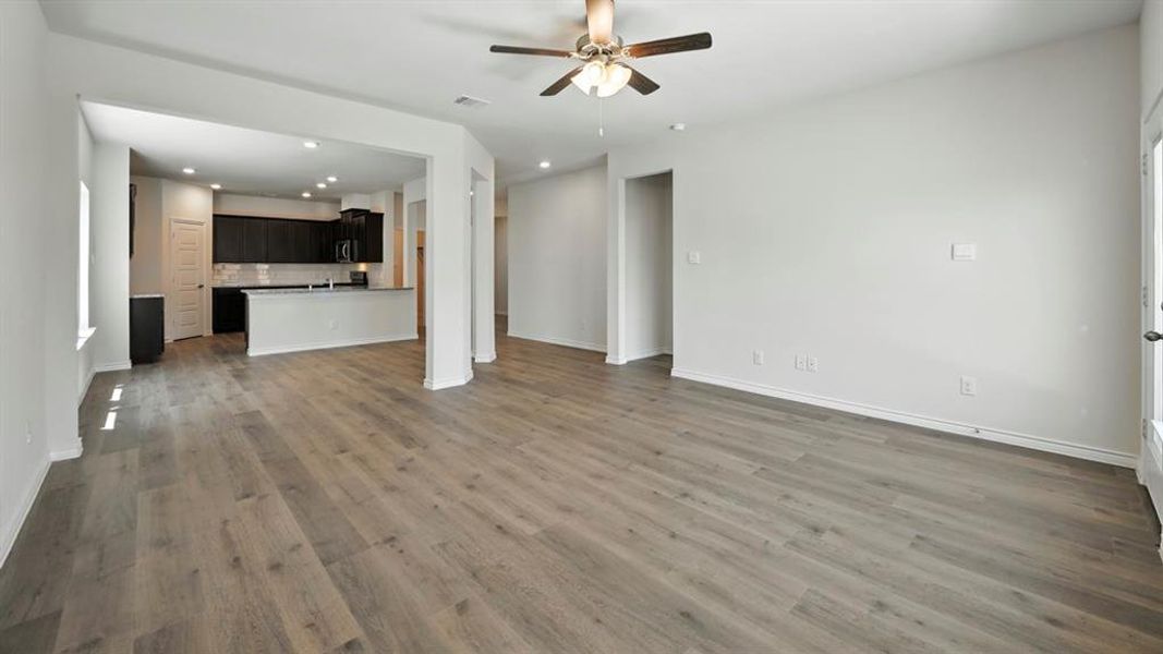 Unfurnished living room featuring recessed lighting, dark wood-style floors, and a ceiling fan