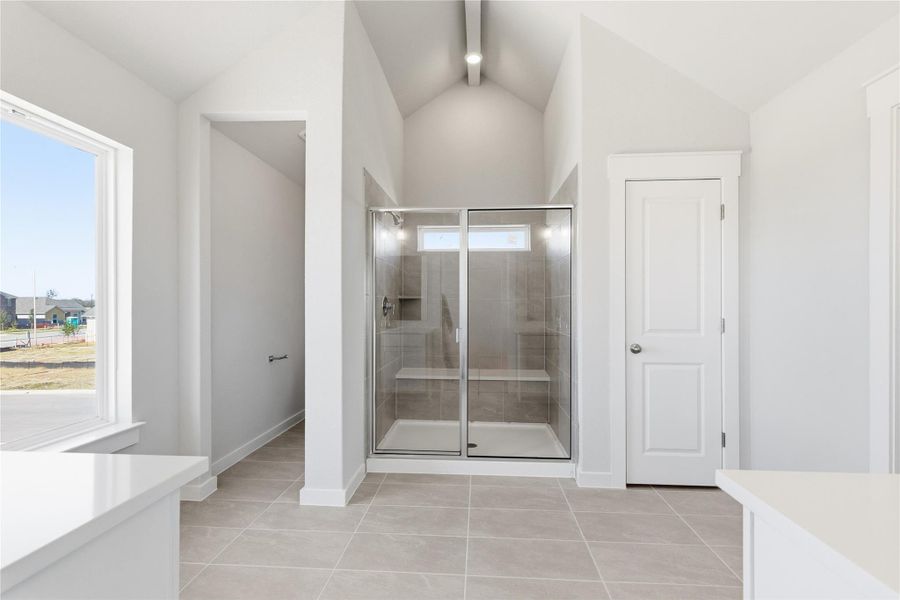 Bathroom featuring light tile patterned flooring, a shower stall, and vanity