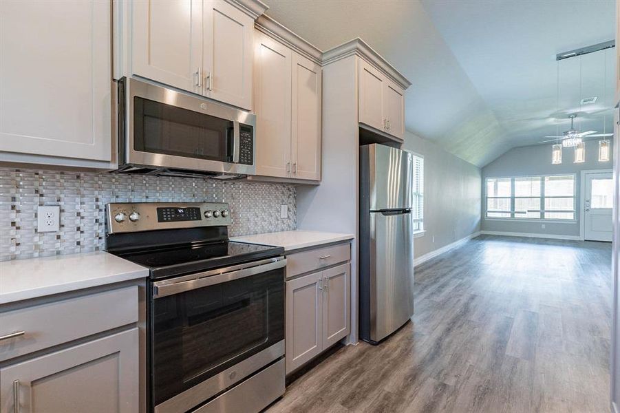 Dream Kitchen with custom glass tile back splash, stainless steel appliances, and full cabinets to the ceiling + custom crown molding.