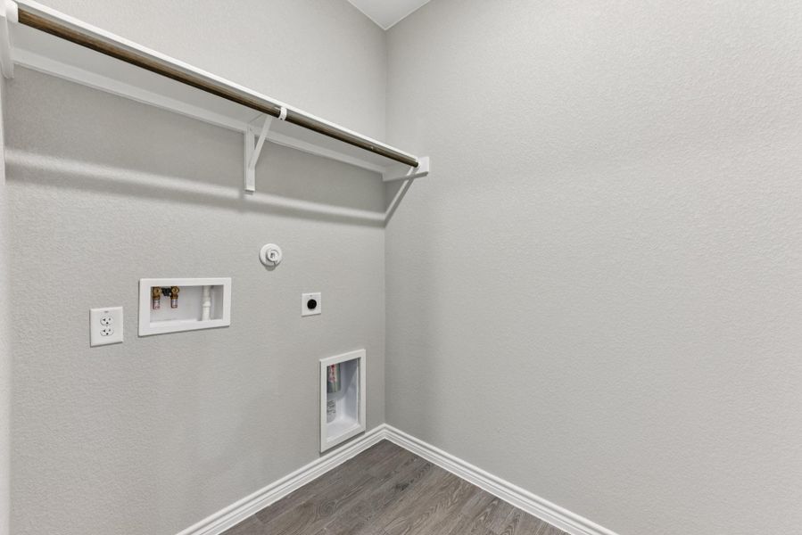 Laundry room with wood finished floors, hookup for a gas dryer, electric dryer hookup, washer hookup, and a textured wall Laundry room with wood finished floors, hookup for a gas dryer, electric dryer hookup, washer hookup, and a textured wall