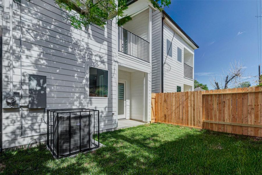 The private backyard provides a manageable lawn space enclosed by a sturdy wooden privacy fence.