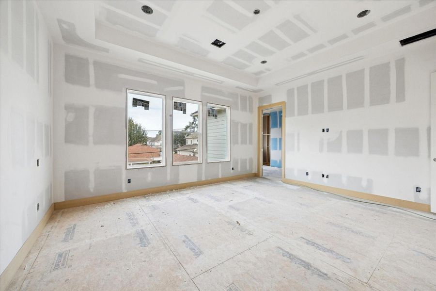 The primary bedroom is thoughtfully sized to accommodate a full suite of furnishings while maintaining an open, airy feel. Multiple windows invite natural light throughout the day, and the layout allows for easy flow into the primary bath and expansive walk in closet, creating a true private retreat within the home.