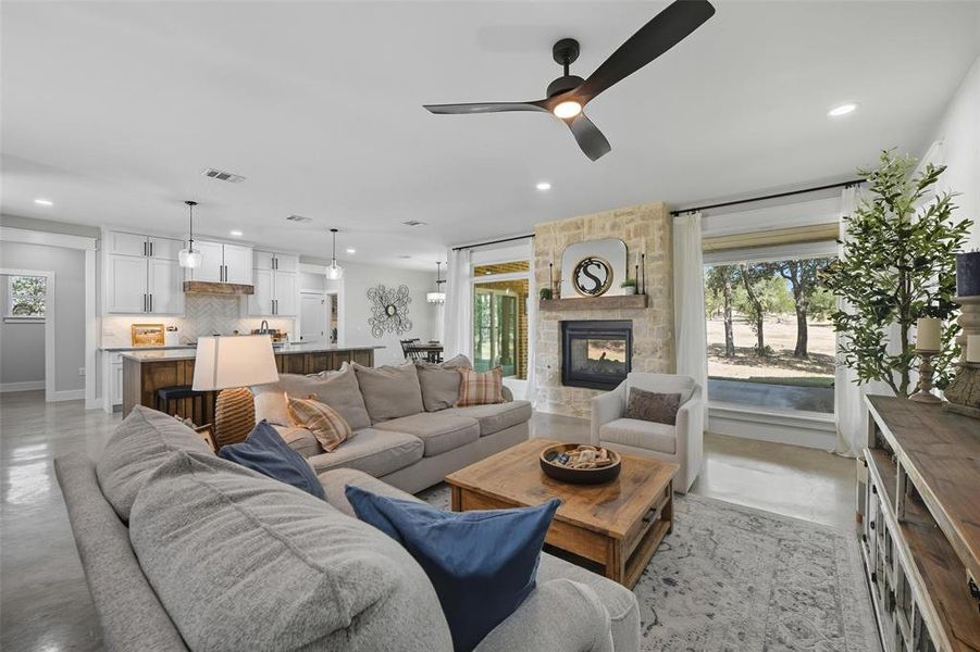Living area featuring ceiling fan, finished concrete flooring, a fireplace, and recessed lighting Living area featuring ceiling fan, finished concrete flooring, a fireplace, and recessed lighting