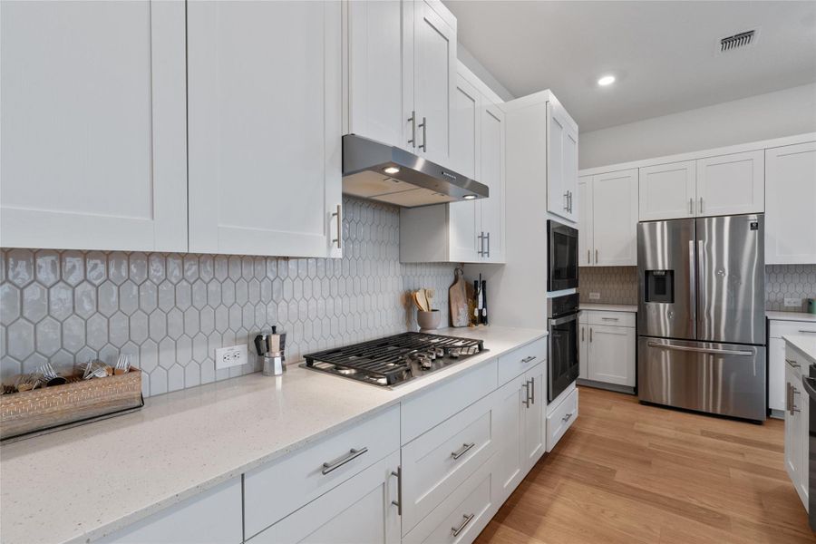Culinary creations come to life in this kitchen, boasting premium appliances and ample counter space.