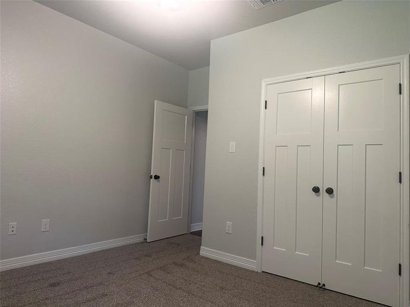 Unfurnished bedroom with carpet and a closet