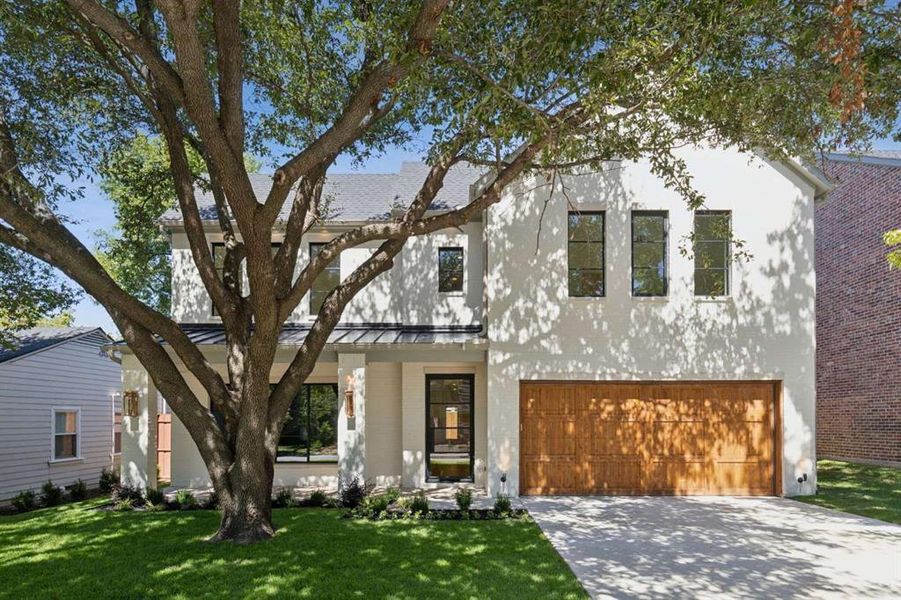 View of front of house with a garage and a front yard