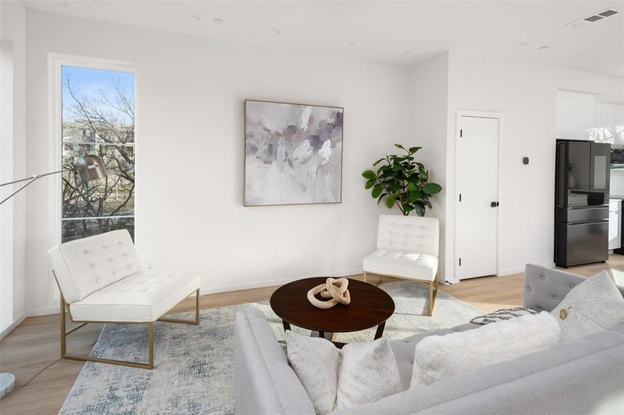 Living room with baseboards, visible vents, and light wood finished floors