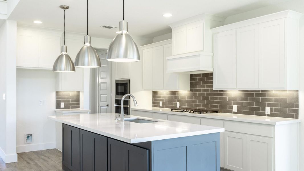 Kitchen with a sink, stainless steel gas cooktop, white cabinetry, light countertops, and decorative backsplash Kitchen with a sink, stainless steel gas cooktop, white cabinetry, light countertops, and decorative backsplash