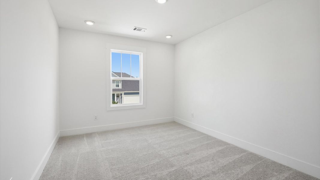 Refined bedroom design with a large window for daylight-filled mornings and peaceful views in Moore, SC
