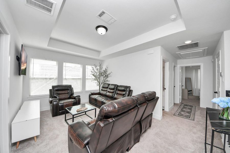 This inviting living area features plush leather seating, ample natural light from large windows, and a modern, neutral color scheme. The space is accented with cozy carpeting, a wall-mounted TV, and a sleek coffee table, perfect for relaxation and entertainment. This inviting living area features plush leather seating, ample natural light from large windows, and a modern, neutral color scheme. The space is accented with cozy carpeting, a wall-mounted TV, and a sleek coffee table, perfect for relaxation and entertainment.