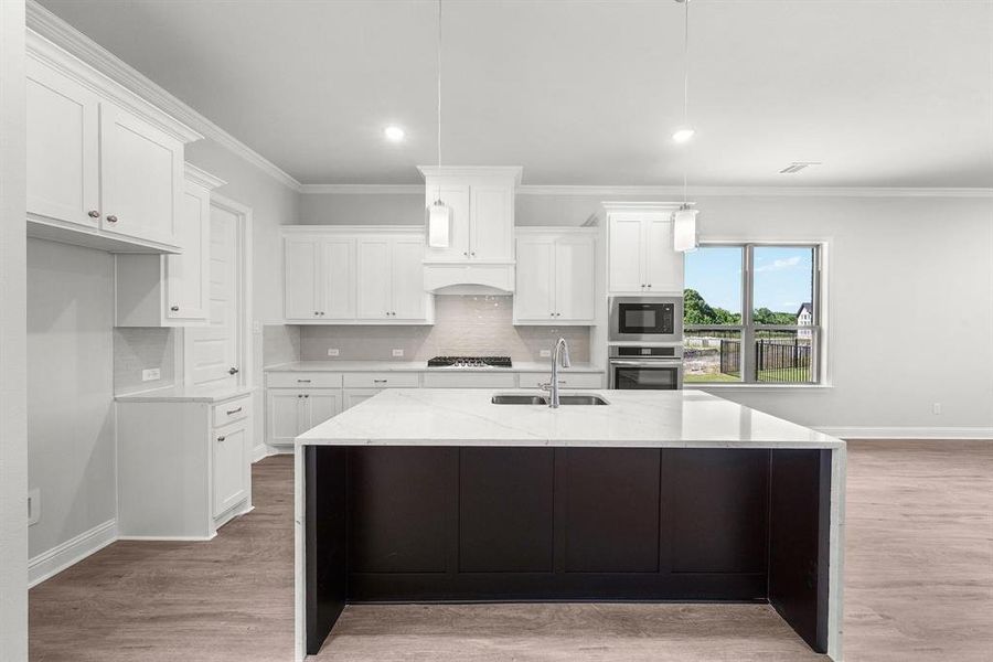 Kitchen featuring tasteful backsplash, crown molding, light granite countertops, white cabinets, and recessed lighting