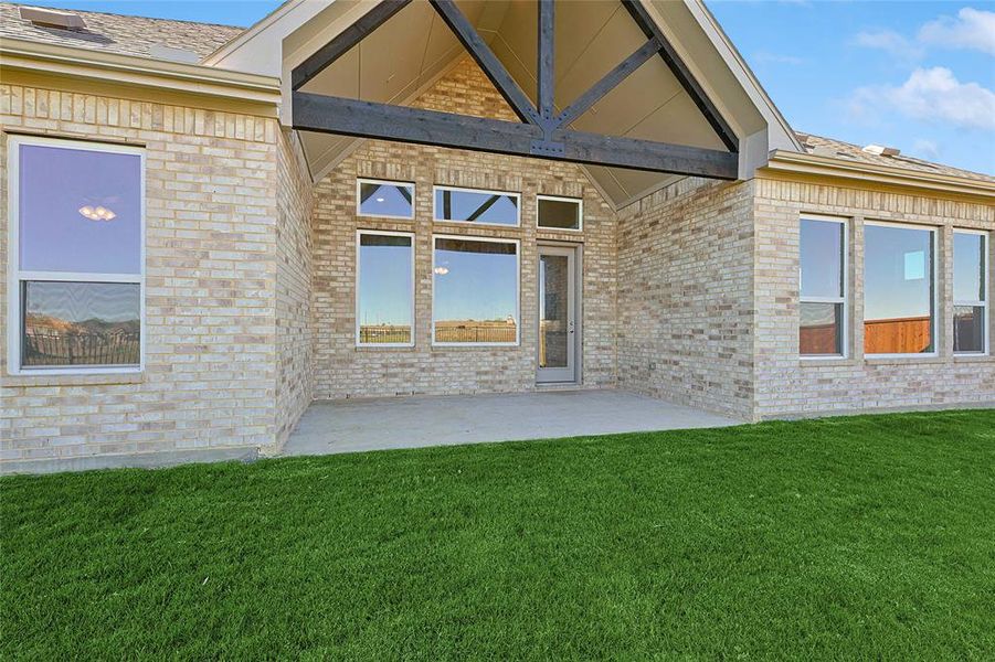 Property entrance featuring a patio and a lawn