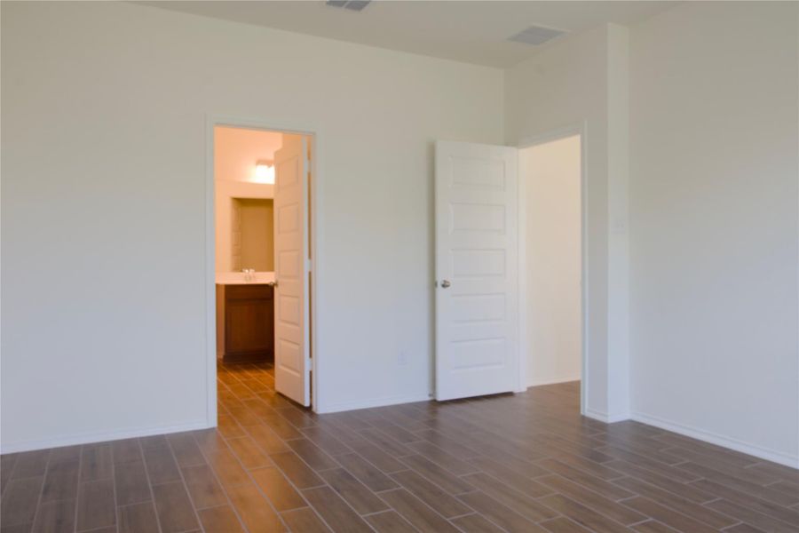 Richly tiled flooring guides you through this serene space to a connected private bath.