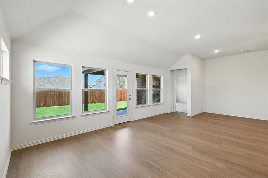 Unfurnished living room with vaulted ceiling, recessed lighting, and light wood finished floors Unfurnished living room with vaulted ceiling, recessed lighting, and light wood finished floors