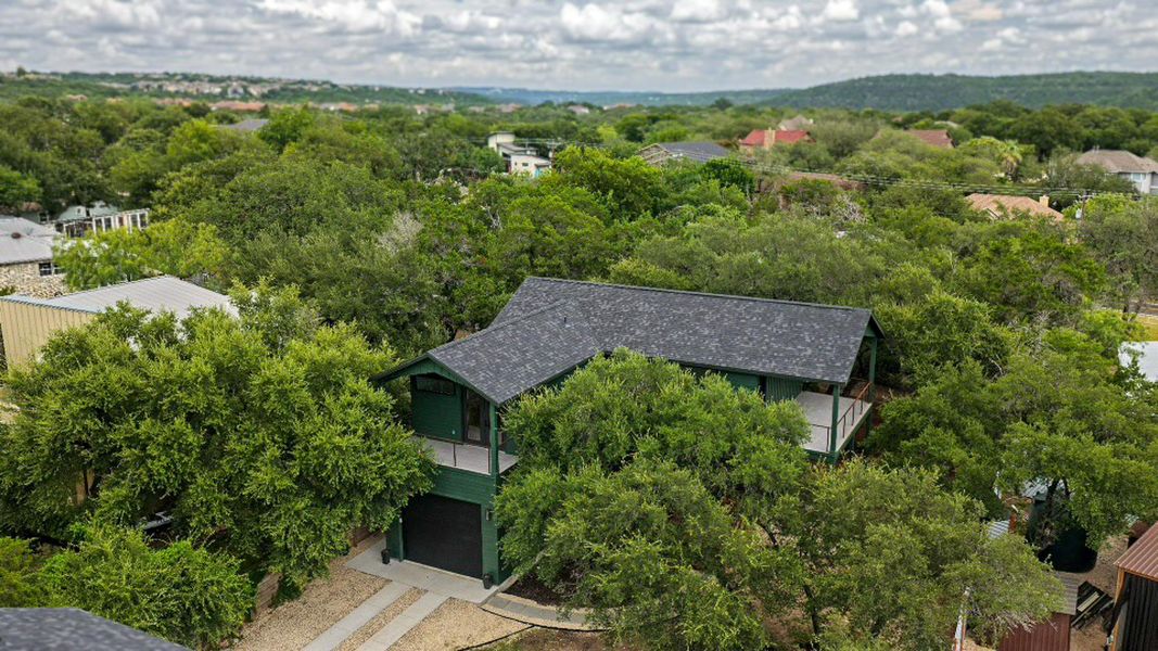 Perched among verdant trees, this elevated residence offers secluded living with distant vistas. Perched among verdant trees, this elevated residence offers secluded living with distant vistas.