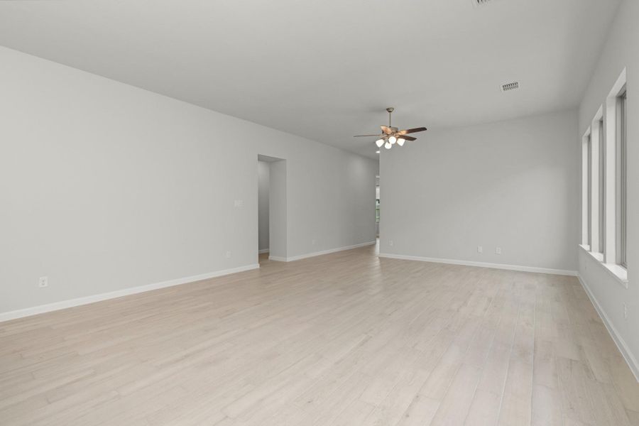 Spacious living room with high ceiling, ceiling fan and neutral finishes.
