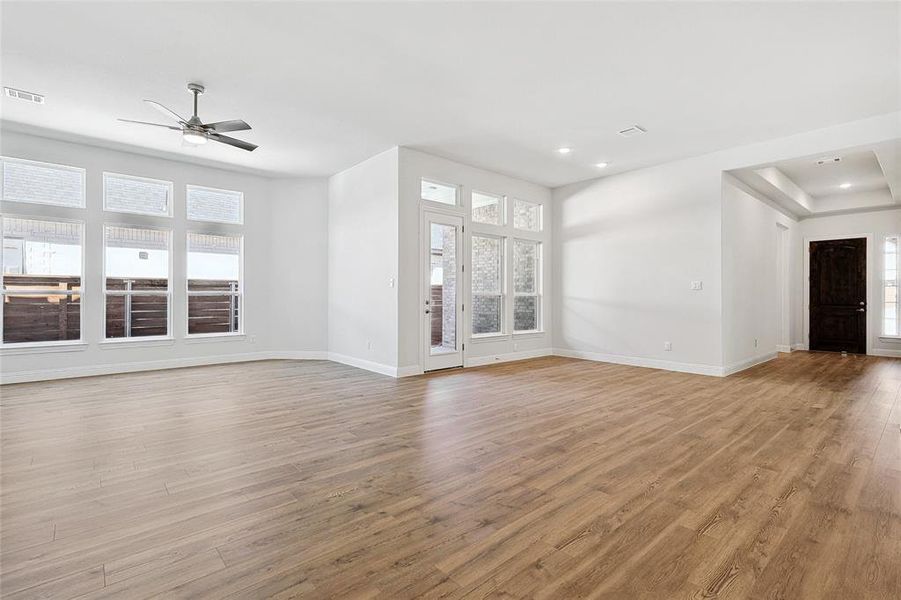 Unfurnished living room featuring light wood-style flooring, a ceiling fan, and recessed lighting