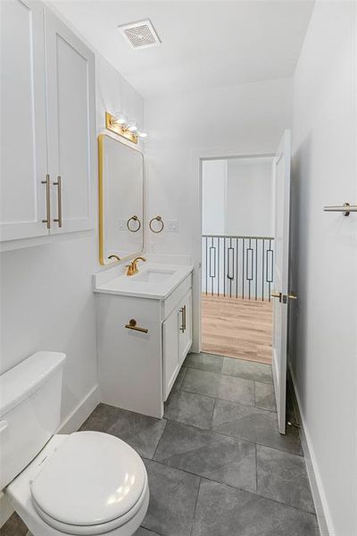 Bathroom featuring vanity, toilet, and hardwood / wood-style flooring