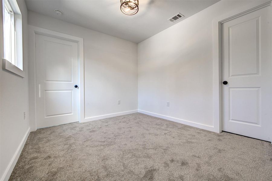 Carpeted spare room featuring baseboards