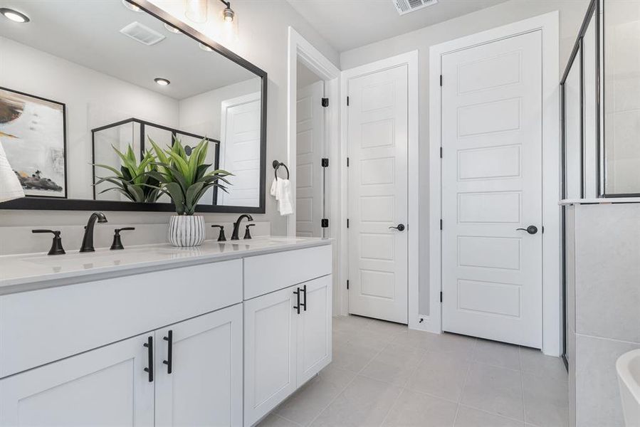 Bathroom featuring vanity, tile patterned floors, and an enclosed shower