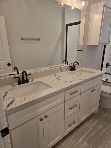 Full bathroom with shower / bath combination with glass door, vanity, and toilet