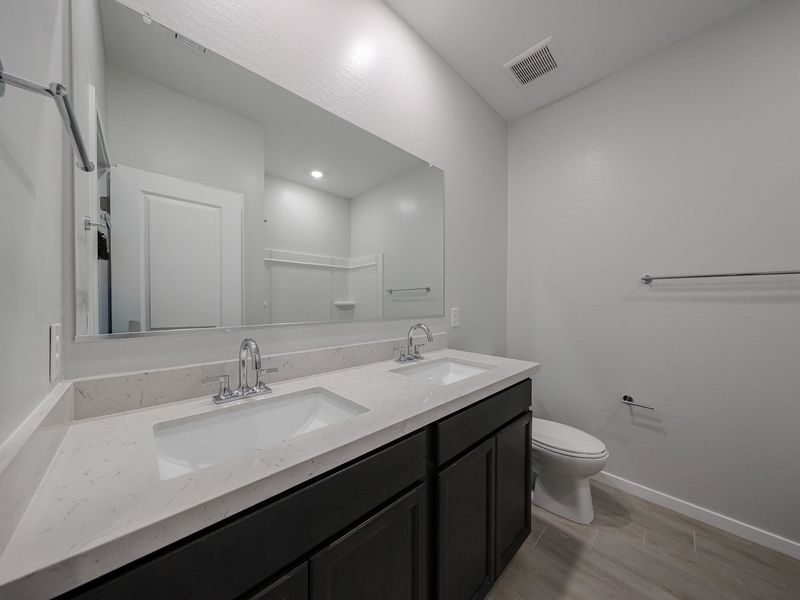 A bathroom with a sink and a toilet. A bathroom with a sink and a toilet.