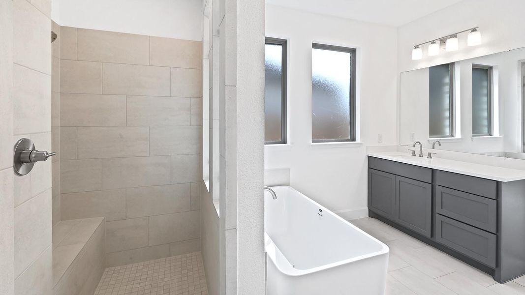 Full bath with a soaking tub, vanity, and a walk in shower