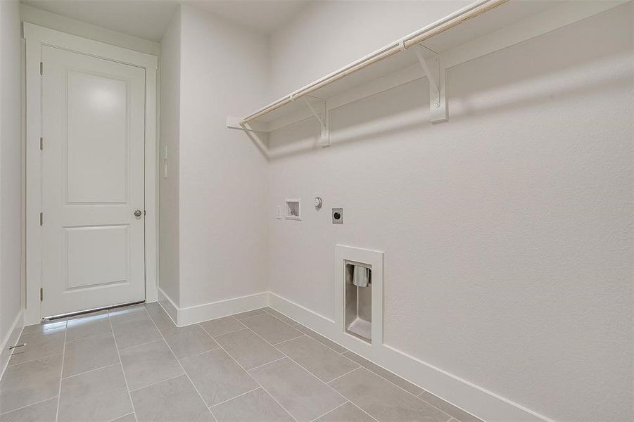 Laundry room with hookup for an electric dryer, light tile patterned flooring, and hookup for a washing machine