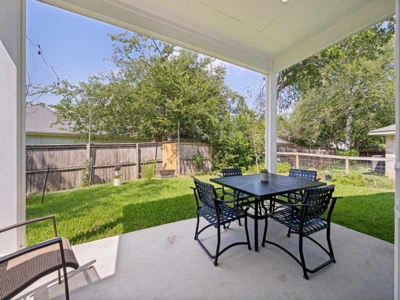 An inviting covered patio offers a comfortable outdoor dining area overlooking the manicured green lawn. An inviting covered patio offers a comfortable outdoor dining area overlooking the manicured green lawn.
