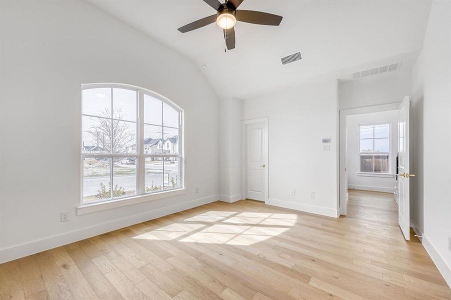 Unfurnished bedroom with light wood-style floors, a ceiling fan, and lofted ceiling