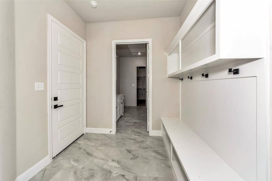 Mudroom with light tile patterned flooring