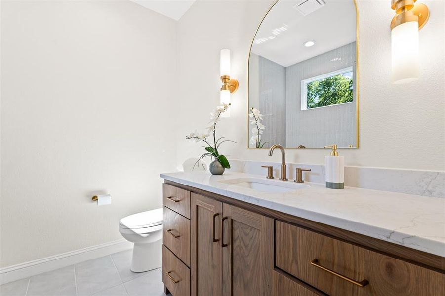 Half bath with vanity and light tile patterned flooring