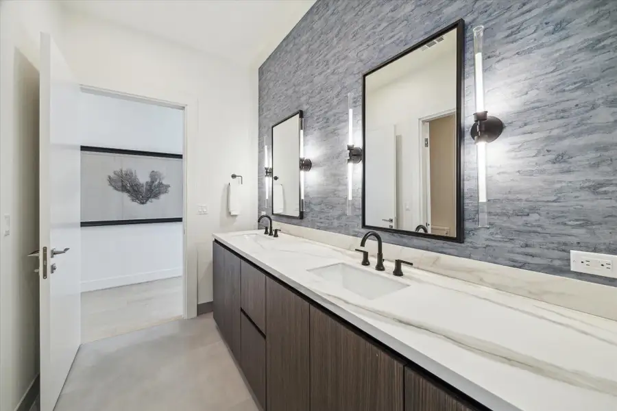This is a beautiful bathroom, with wallcovering and designer lighting, shared by the two secondary bedrooms.