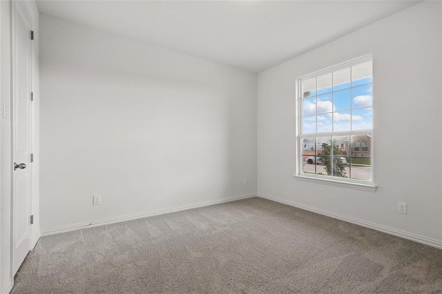 Empty room featuring carpet flooring and baseboards Empty room featuring carpet flooring and baseboards
