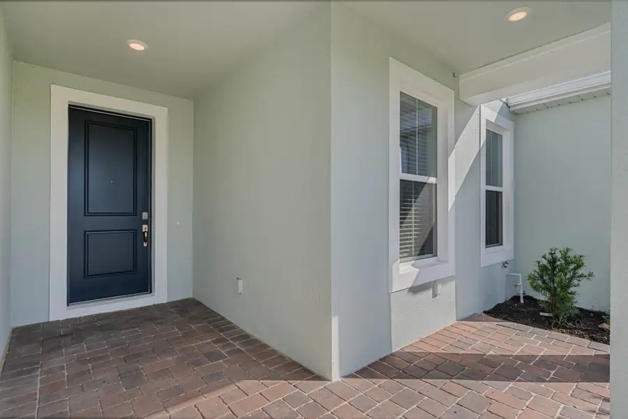 Exterior details and patio area of a home in Harvest at Ovation - Townhomes, Winter Garden (Image 2).