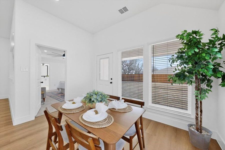 Dining room featuring light wood-style flooring, lofted ceiling, and ceiling fan Dining room featuring light wood-style flooring, lofted ceiling, and ceiling fan