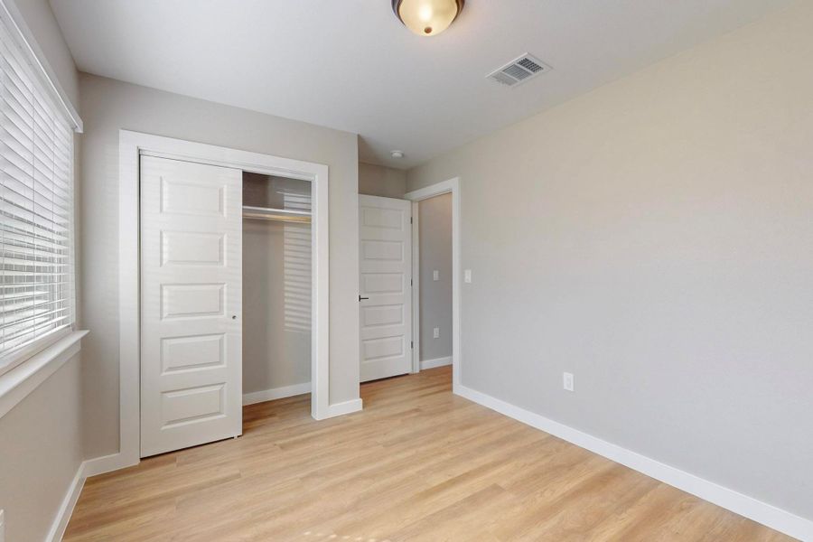Unfurnished bedroom featuring visible vents, baseboards, and light wood-type flooring