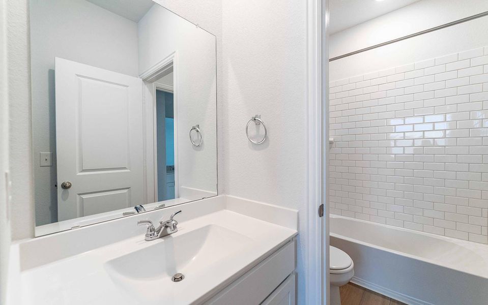 Full bathroom with vanity, shower / tub combination, and dark wood-style flooring