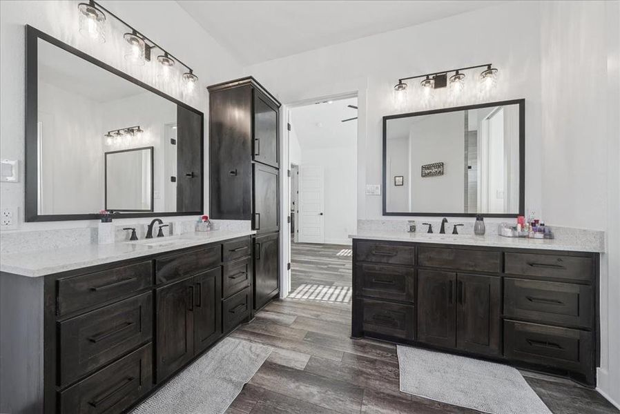 Bathroom with two vanities and dark wood-type flooring