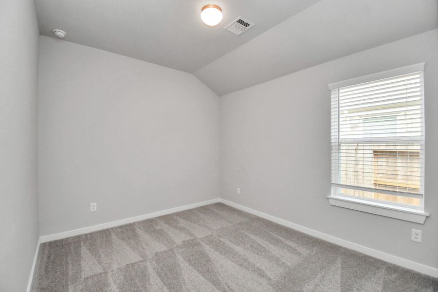 Secondary bedroom features plush carpeting, large windows that let in plenty of natural light, bright paint, and spacious closets.