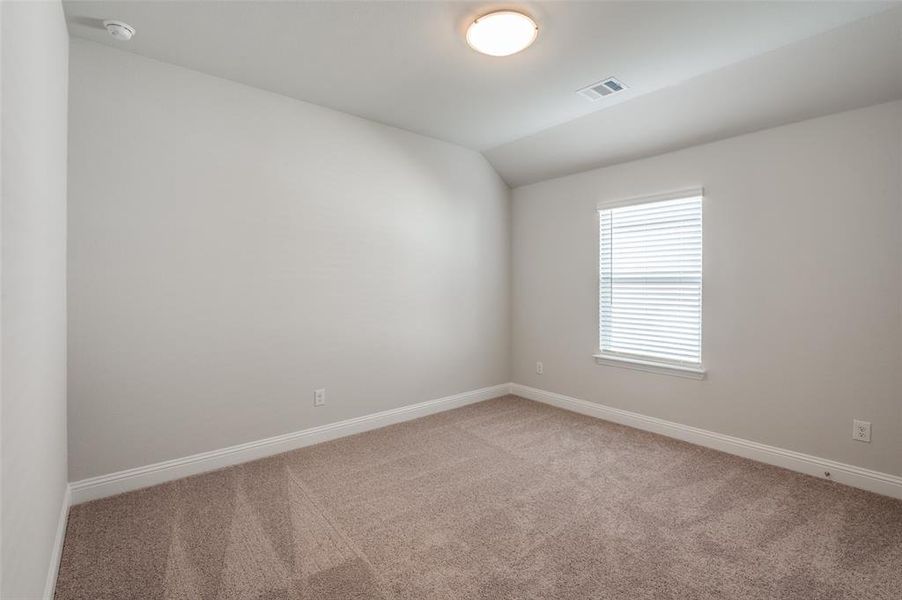 Carpeted room featuring a single window with blinds, a ceiling-mounted light fixture, and a white baseboard trim